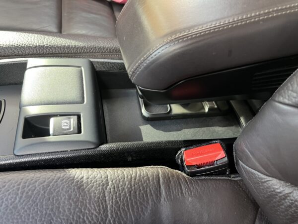 BMW i3 accessory that creates a hidden compartment and shelf under the armrest